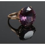 A 14ct gold ring with large purple facetted stone and crown shank. Size O. Gross weight: 8g.