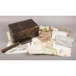 A wooden writing box with contents of collectables and ephemera. Includes World War One souvenir