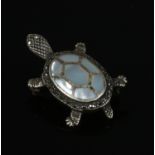 A silver tortoise brooch with mother of pearl inlay. 3.5 cm length.