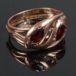 A 9ct rose gold double serpent ring set with garnets. 5.24g.