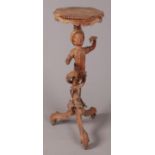 A 19th century carved figural torchiere column raised over a tripod base.