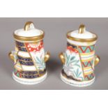 A pair of small Royal Crown Derby twin handled lidded pots. (8cm high) Chip to base of one pot.