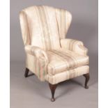 A fabric upholstered Wingback Armchair with floral and striped pattern. Stains to upholstery,