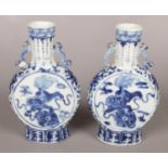 A pair of 19th century Kangxi blue and white moon flasks. Decorated with temple lions. 21cm.