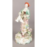 An 18th century Derby porcelain figure, modelled as a maiden collecting flowers with a lamb at her