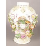 An 18th century Derby porcelain vase with pierced neck, decorated with two masks, painted insects