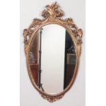 An ornate oval mirror with decorative gilt frame. Size of mirror - Height: 60cm, Width: 39cm.