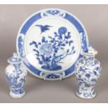 Three pieces of Chinese blue and white ceramics. Includes two lidded vases and a plate.