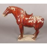 A Chinese Tang dynasty style painted and glazed sculpture of a horse. 35cm.