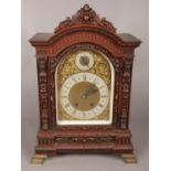 A 19th century carved oak bracket clock by Lenzkirch. Brass arched dial with silvered chapter ring