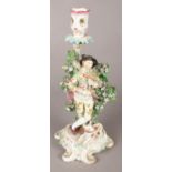 An 18th century Derby porcelain figural candlestick, modelled as a bagpipe player and dog, with