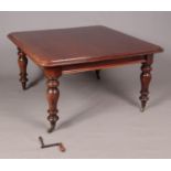 A Victorian mahogany wind out dining table raised on turned supports. With three additional leaves.
