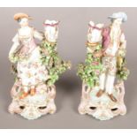 A pair of 18th century Derby porcelain figural candlesticks modelled as a lady and gentleman with