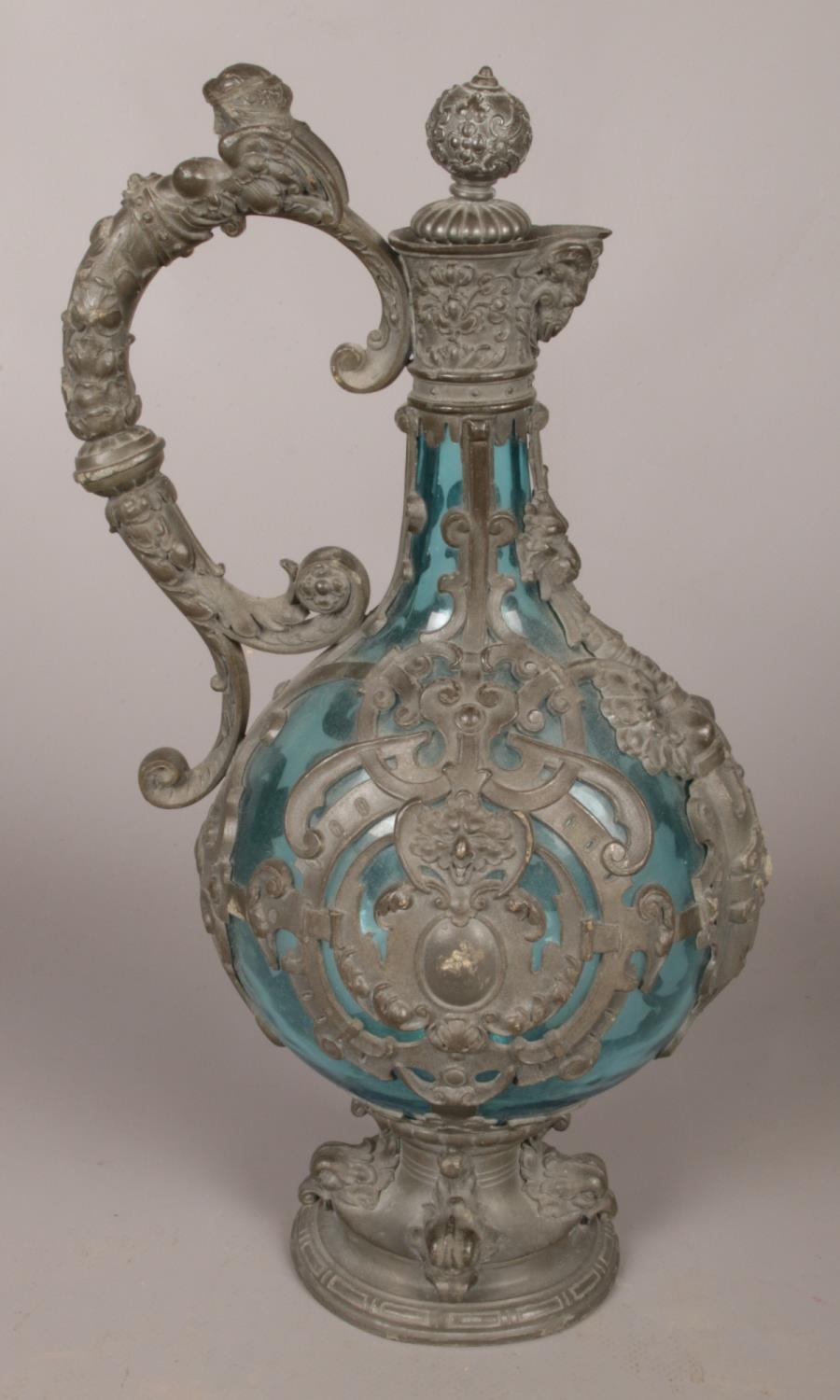 A 19th century blue glass ewer with pewter mounts and mask decorations. 29cm.