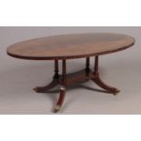 A Regency style mahogany oval coffee table with brass inlaid decoration. Height 47cm, Length