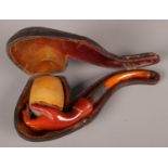 A 19th century cased meerschaum pipe formed as a hand holding the bowl. With amber stem.