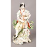 An 18th century Derby porcelain figure, modelled as bagpipe player with a dog. 18.5cm. Repair to bag