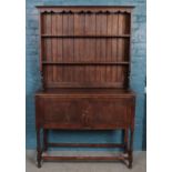 An oak Welsh dresser with cupboard base and turned supports.