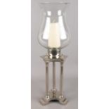 A modern chrome candle holder with large glass shade. Small chip to the base.