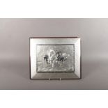 A silver plaque depicting horses in canter (stamped 925 to bottom left) in a white metal frame