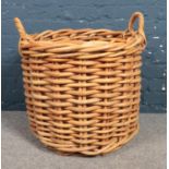 A large round twin handled wicker basket. 54cm height 63cm diameter.