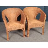 A pair of wicker weaved conservatory chairs.