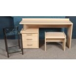 A modern desk with fabric topped seat, together with two-tier tubular steel and glass bedside