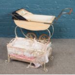 A vintage baby's pram, together with a Baby Annabel metal cot and linen.