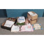 Three boxes of assorted linens. To include embroidered table cloths, napkins and aprons etc.