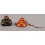 Two Buddha netsukes. To include a composite Buddha with erotic carving underneath. H: 5cm.