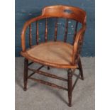 A carved oak spindle back armchair with bergere seat.