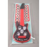 A Rolling Stones plastic toy guitar in original packaging.