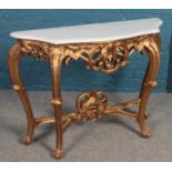 A gold painted, marble topped demilune table with cabriole legs.