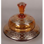 An Art Deco amber coloured glass lidded bon bon dish. With silver overlay decoration and faceted