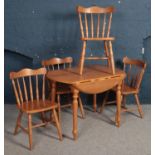 A Pine kitchen drop leaf table with four chairs. Scratch to the base of one of the chairs.