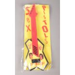 A Sex Pistols plastic toy guitar in original sealed plastic packaging.