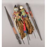 Two Indonesian stick puppets along with a pair of African tribal spears.