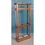 An oak coat and stick stand with two removable drip trays. Height 170cm, Width 69cm, Depth 23cm.