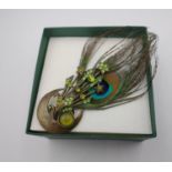 Unusual boxed ladies brooch with peacock feather and green stones.