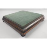 An cEDWARDIAN restrained square footstool only 6cm high with a wooden base and sea green velour