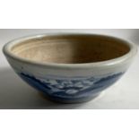 An antique CHINESE ground pottery bowl with a blue and white pattern and with faint red base