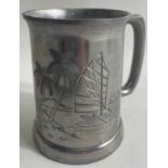 Glass-bottomed pewter tankard with a design of palm trees and a Chinese junk, stands 12cm high.