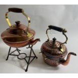 TWO ANTIQUE COPPER KETTLES one beaten with stand 32cm tall approx, the other approx 20cm tall