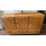 An ERCOL sideboard in light wood finish, two cupboards and two drawers, ERCOL label to the inside