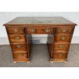 Vintage c1900 kneehole oak desk with green leather top, on bun feet, middle drawer, four