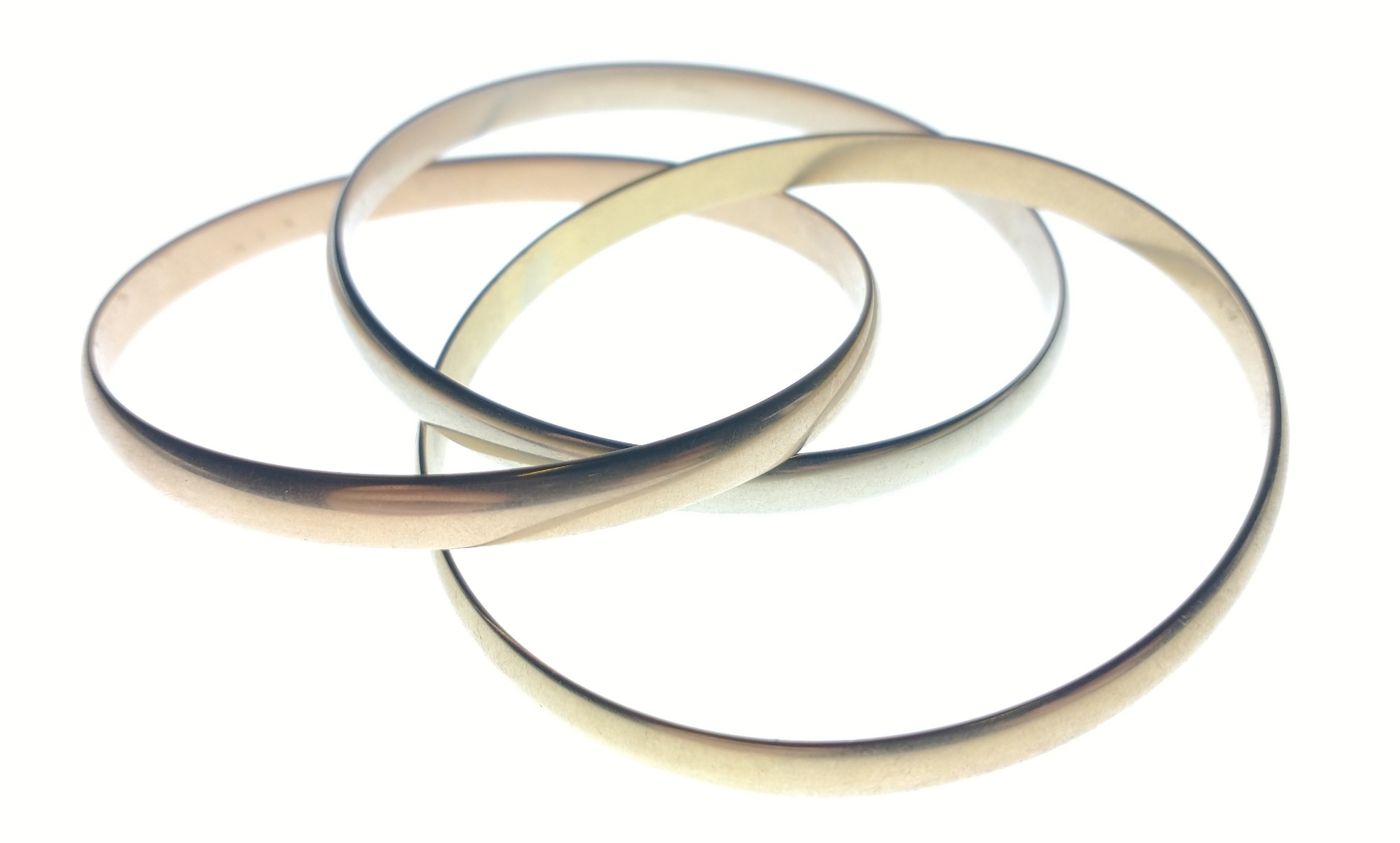 CARTIER - A SUBSTANTIAL gold BANGLE, Cartier.Three tri-tone gold interlocking bangles