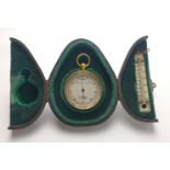 A vintage brown, leather TRIPTYCH with green velvet lining with a pocket BAROMETER (4cm diameter)