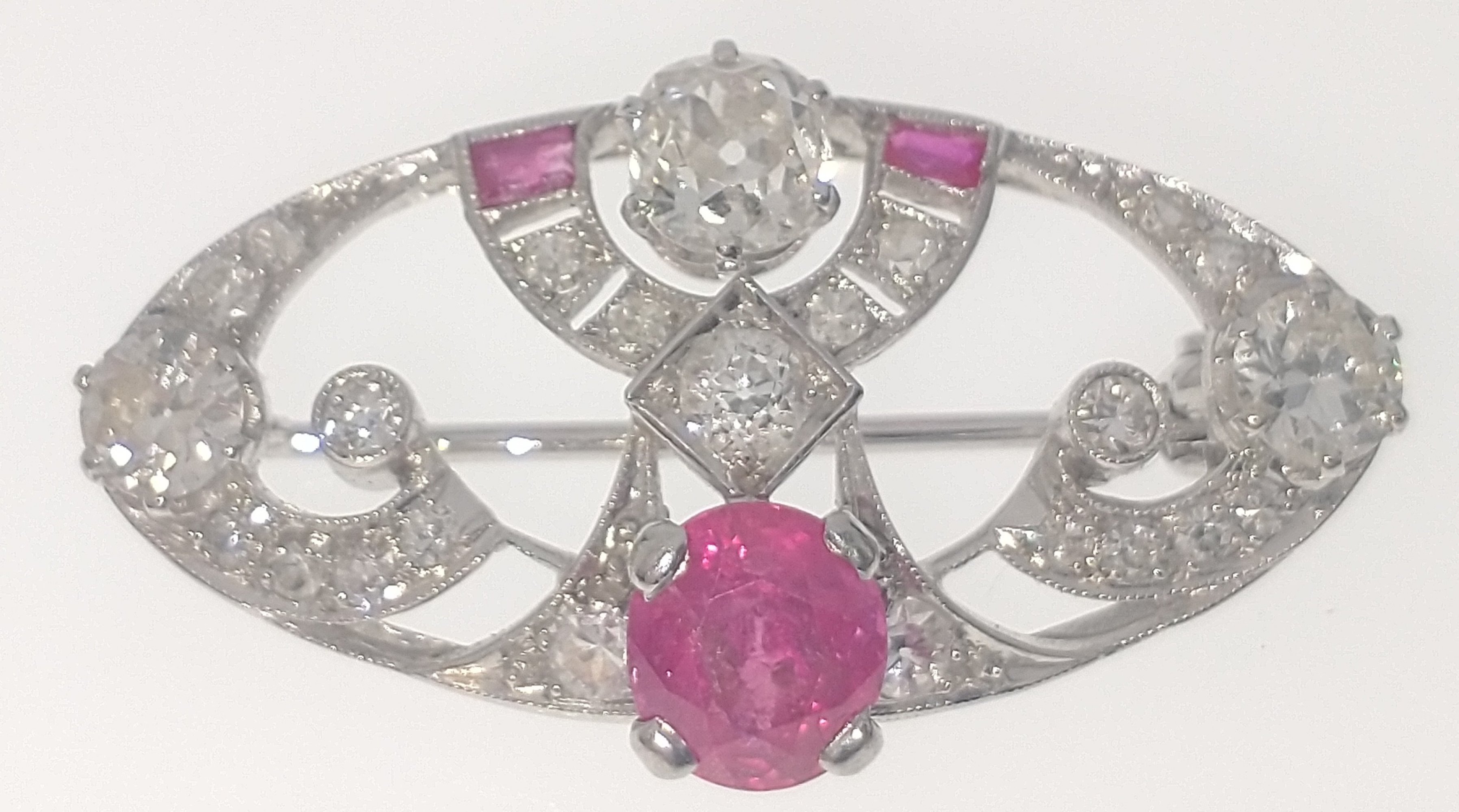 A VINTAGE DIAMOND encrusted 'white metal' pin BROOCH with a central pink stone (0.5cm diameter)