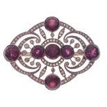 ORNATE STUNNING ART DECO DESIGN! An unmarked diamond and garnet set BROOCH, with 7 round faceted