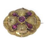 A VICTORIAN 'yellow metal' oval BROOCH with a leaf and flower bud design, set with 5 amethysts -